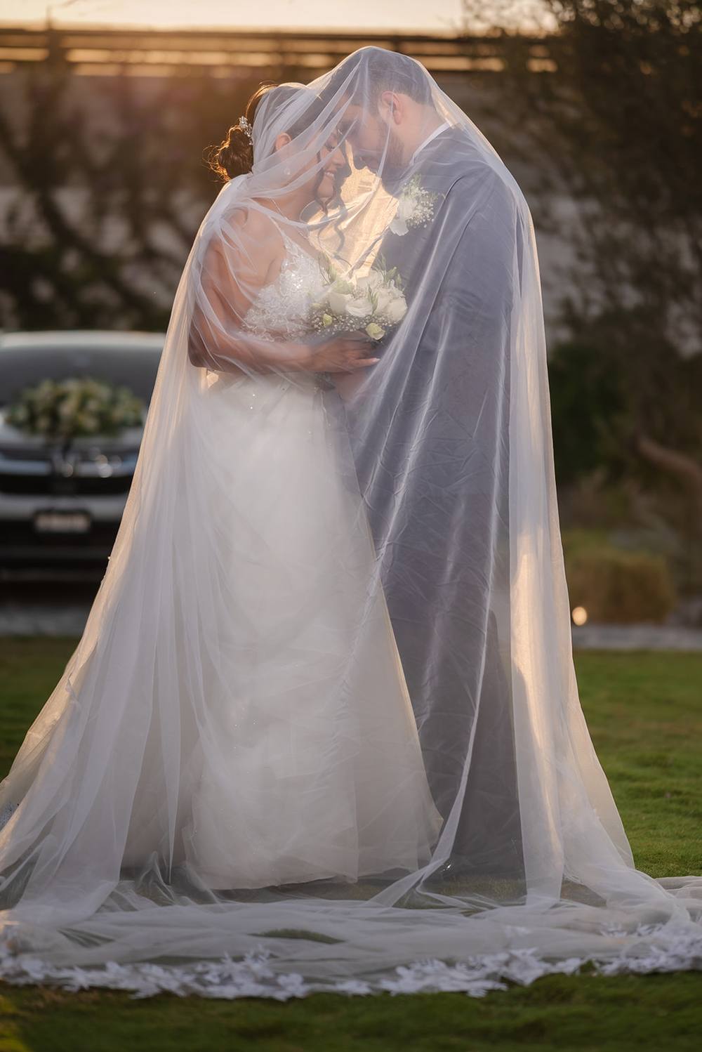 Novios bajo el velo al atardecer, David Roche Photography